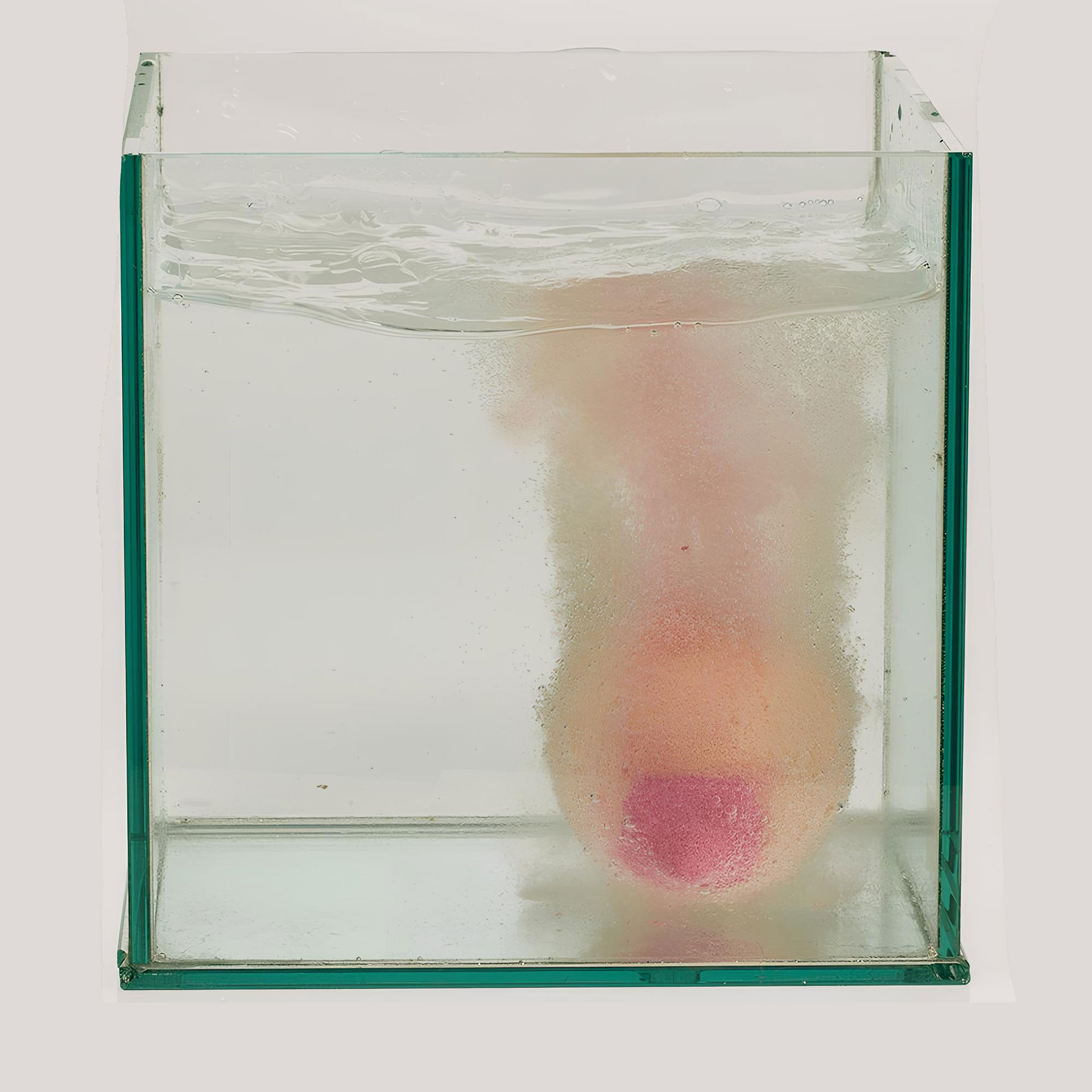 Eine sich sprudelnd in einem Wasserbecken auflösende Badekugel in Form einer weiblichen Brust
